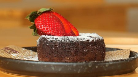 Téléchargez les photos : Gâteau au chocolat aux fraises fraîches. Gâteau au chocolat riche avec une couche de fondant, garni de fraises fraîches et de glaçage au sucre. Tarte aux baies au chocolat noir - en image libre de droit