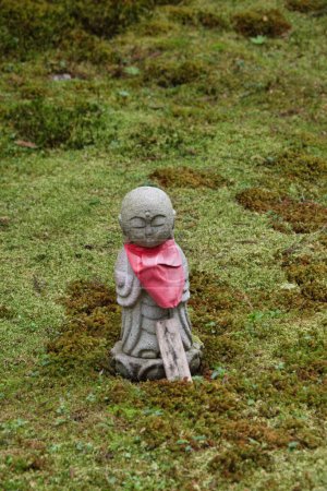 Foto de A Jizo statue standing in the moss-covered garden.  Kyoto Japan - Imagen libre de derechos