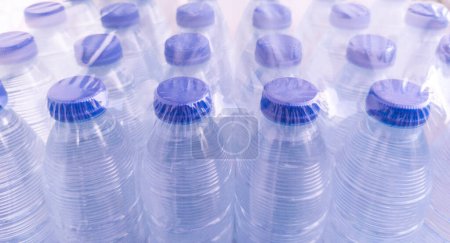 Téléchargez les photos : Lot de petites bouteilles d'eau emballées sous film rétractable. Concept de pollution des bouteilles d'eau en plastique - en image libre de droit