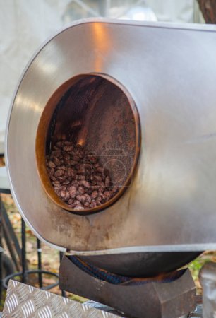 Photo for Garrapinadas processing at rotatory pot. Traditional caramel-coated almonds been processed at fair stall - Royalty Free Image