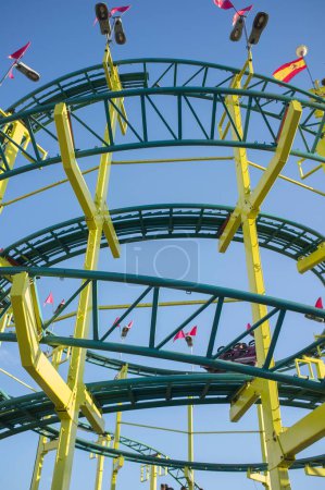 Foto de Roller coaster circles structure. Funfair attraction over blue sky seen from ground - Imagen libre de derechos