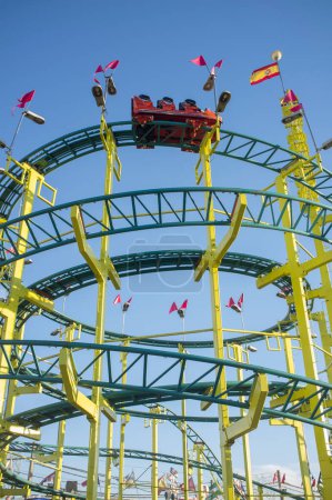 Foto de Roller coaster circles structure. Funfair attraction over blue sky seen from ground - Imagen libre de derechos