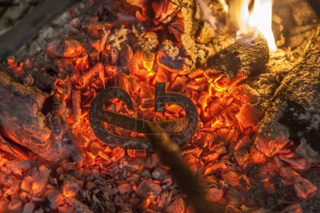 Foto de Heating branding iron for cattle over embers. Selective focus - Imagen libre de derechos