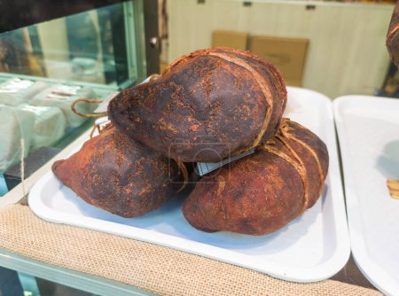 Téléchargez les photos : Extremaduran buche displayed at butchers shop. Pork stomach stuffed with ribs, tail, tongue and snout - en image libre de droit