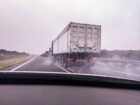 Téléchargez les photos : Driving behind large truck with heavy rain. Bad-weather driving concept - en image libre de droit