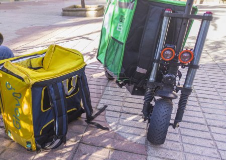 Téléchargez les photos : Caceres, Espagne - 19 Jan, 2021 : Livraison de sacs à dos et scooters électriques. Contexte urbain - en image libre de droit