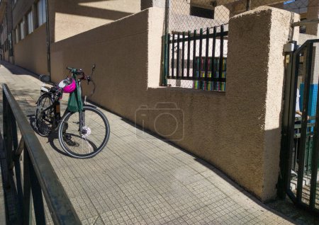 Photo for Electric bike parked on the sidewalk, near primary school door. Drop kids off right at school - Royalty Free Image