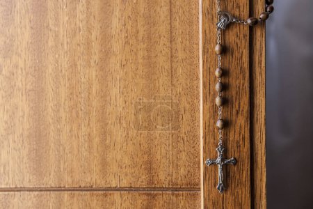 Photo for Catholic rosary hanging from wooden door. Selective focus - Royalty Free Image