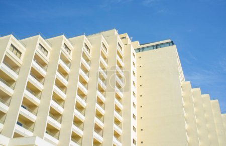 Foto de Bloque claro de pisos sobre el cielo azul. Arquitectura frente al mar de los años setenta - Imagen libre de derechos