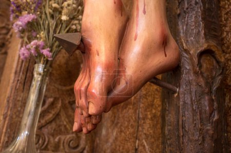 Photo for Feet of a crucified Christ pierced by a nail. Selective focus - Royalty Free Image