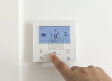 Téléchargez les photos : Réglage de la climatisation de la pièce avec écran électronique. 19 degrés Celsius cool ajuster - en image libre de droit