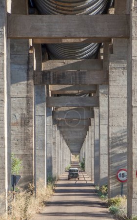 Téléchargez les photos : Véhicule traversant la route sous l'aqueduc d'Acedera, Vegas Altas del Guadiana, Badajoz, Estrémadure, Espagne - en image libre de droit