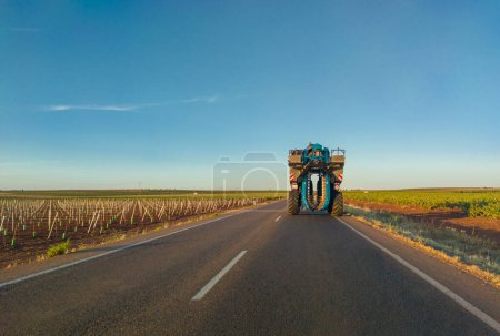 Photo for Grape harvester driving along a rural road between vineyards in the region of Tierra de Barros, famous wine-making region - Royalty Free Image