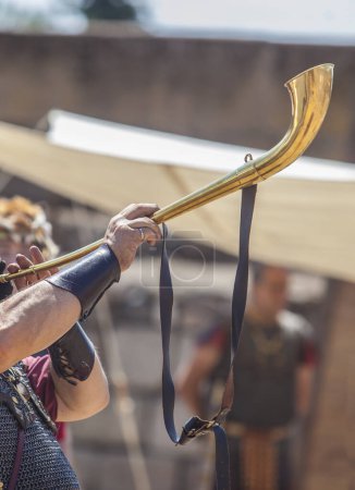 Téléchargez les photos : Reenactor soufflant un lituus, un ancien instrument romain en laiton aigu - en image libre de droit