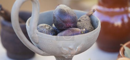 Photo for Clay cup full of mature figs. Ancient roman gastronomy concept - Royalty Free Image