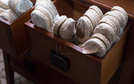 Photo for Wooden drawer full of white espadrille shoes. Disposable shoes for wedding guests - Royalty Free Image