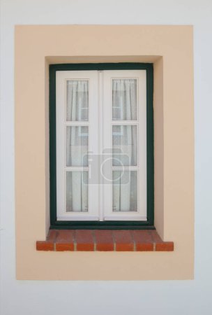 Foto de Pequeña ventana pintada con colores vivos en la casa de Vila Nova de Milfontes. Pequeña ciudad pintoresca en la costa del Alentejo, Portugal - Imagen libre de derechos