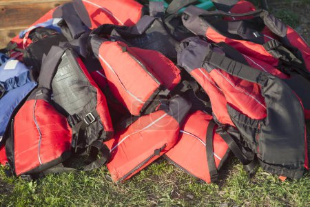 Photo for Life jackets piled up on the grass. Active tourism at freshwaters coasts concept - Royalty Free Image