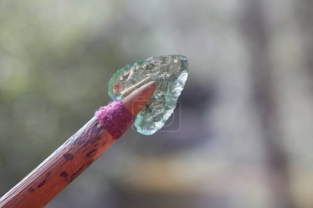 Photo for Prehistorical arrowhead built in short shaft. Replica made of glass for educational purposes - Royalty Free Image