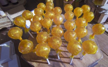 Foto de Piruletas de miel exhibidas en un puesto de mercado tradicional. Concepto de caramelo saludable - Imagen libre de derechos