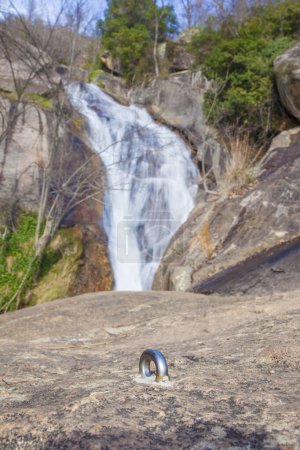 Photo for Bolt fixed over drilled rock for canyoning practice. Nogaleas waterfall as background - Royalty Free Image