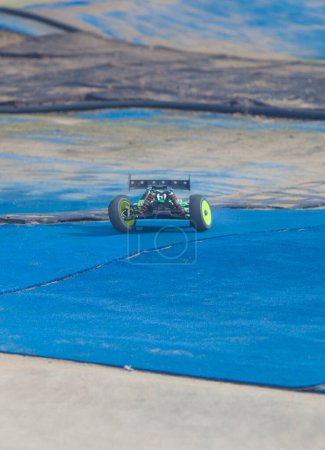 Photo for Merida, Spain - Jan 28th, 2024: Extremadura 1/8tt gas Championship RC Car. Cars making a curve over blue turf - Royalty Free Image