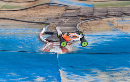 Photo for Merida, Spain - Jan 28th, 2024: Extremadura 1/8tt gas Championship RC Car. Cars making a curve over blue turf - Royalty Free Image