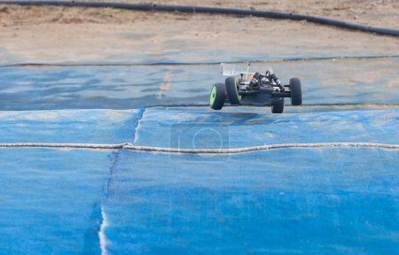 Foto de Mérida, España - 28 de enero de 2024: Extremadura 1 / 8tt gas Championship RC Car. Saltar sobre césped azul - Imagen libre de derechos