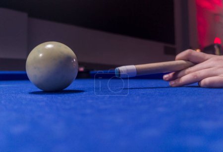 Player about to hit the cue ball. Eight-ball pool game