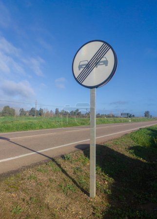End of prohibition on overtaking metal pole. Rural local road background
