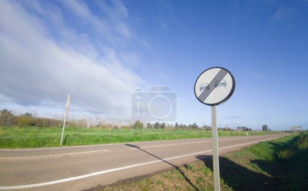 Photo for End of prohibition on overtaking metal pole. Rural local road background - Royalty Free Image