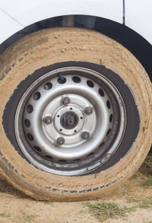 Car wheel completely covered in mud. Total loss of tire grip