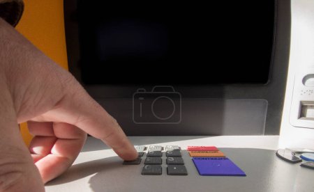 Reifer Mann drückt Passwort-Nummer am Geldautomaten Zugängliche Tastatur
