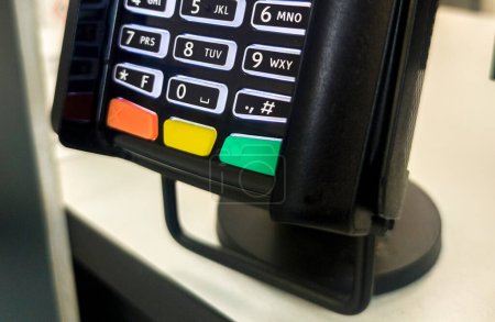 Payment terminal fixed to a counter-top. Focus numeric keyboard
