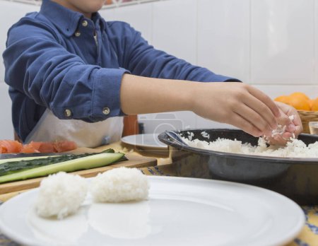 Junge bereitet hausgemachtes Sushi zu. Kinderfreundliche Aktivitäten in der Küche