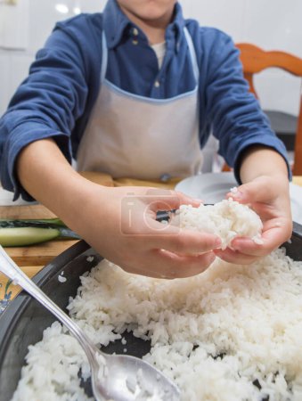 Junge bereitet hausgemachtes Sushi zu. Kinderfreundliche Aktivitäten in der Küche