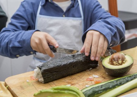 Child boy preparing homemade sushi. Kid-Friendly Kitchen Activities