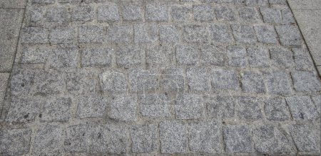 Sett pavement made with quarried granite cubic blocks without roughing. Monumental Complex road surfaces, Caceres, Spain