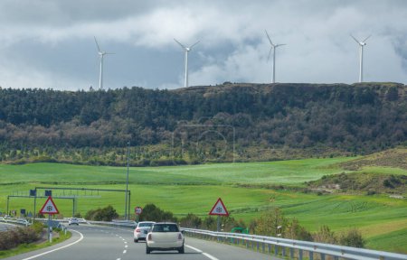 Turbinas eólicas en la cima de las colinas. Paisaje visto desde autopista o autovía