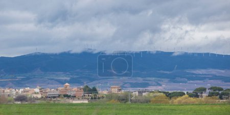 Photo for Wind turbines on the top of the hills. Little town in the foreground - Royalty Free Image