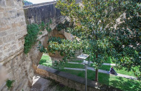 Téléchargez les photos : Pèlerin reposant à côté du pont roman de Puente La Reina, Navarre, Espagne - en image libre de droit