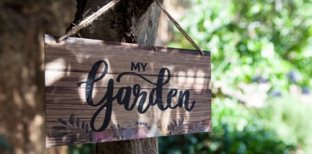 Señal de jardín con patio mediterráneo como fondo. Letras en inglés