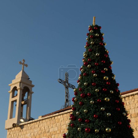 Foto de Árbol de Navidad decorado con bolas festivas cerca de la Iglesia Católica en Haifa - Imagen libre de derechos