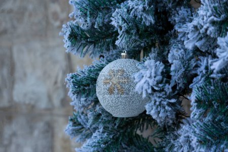 Foto de Sobre las ramas de un árbol de Navidad una bola cubierta de nieve - Imagen libre de derechos