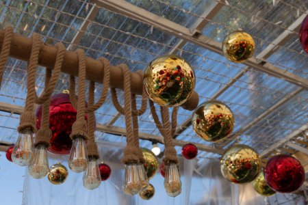 Foto de Bolas de Navidad y bombillas con cuerdas suspendidas bajo el techo - Imagen libre de derechos
