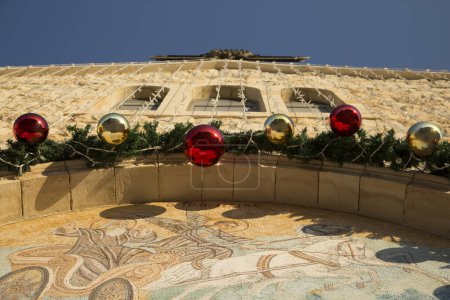 Foto de Decoración de guirnaldas para la fiesta de Navidad en la fachada de la iglesia - Imagen libre de derechos