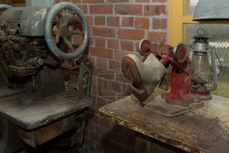 Foto de Máquinas de reparación de calzado en desuso en zapatería con pared de ladrillo rojo - Imagen libre de derechos
