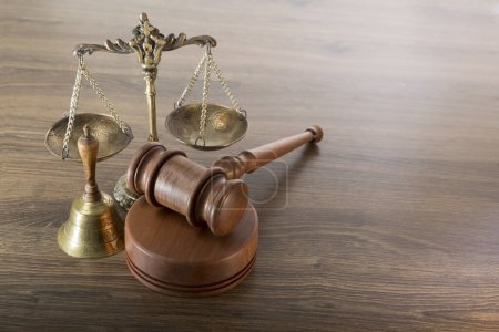 Foto de Judge's gavel, bronze antique scales and a bell on a wooden table - Imagen libre de derechos