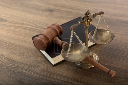 Foto de Scales, judge's gavel and a book of judicial laws on a wooden table - Imagen libre de derechos