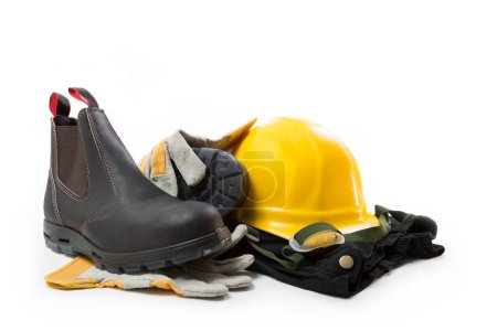 Foto de High boots for work, yellow hard hat, black trousers and gloves on a white background - Imagen libre de derechos